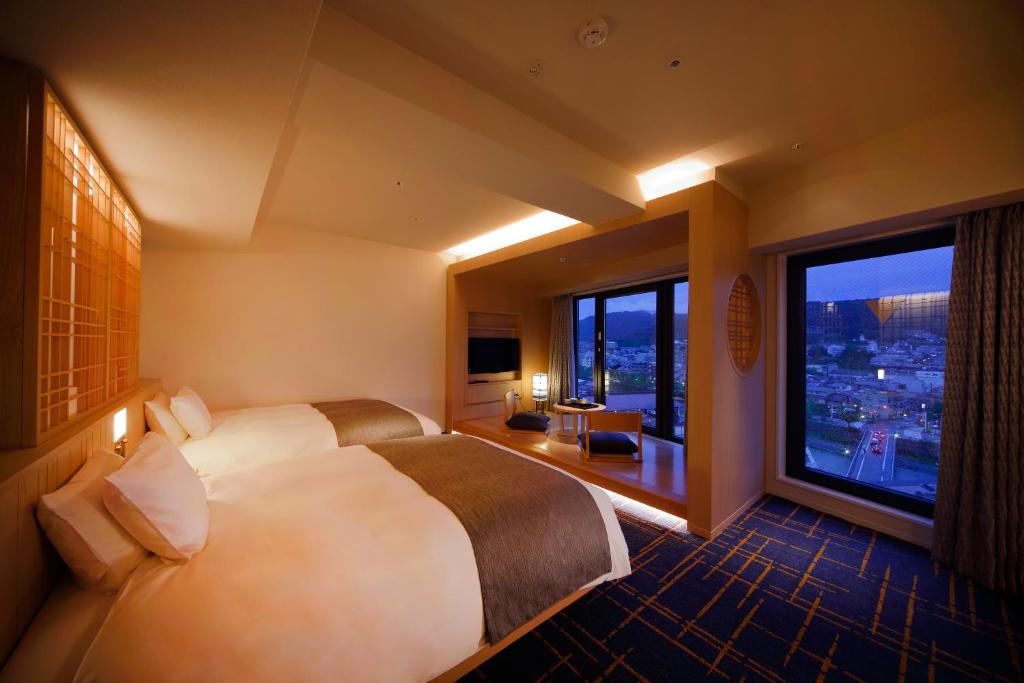 京都SH by the square hotel Kyoto Kiyamachi的酒店客房设有两张床和大窗户。