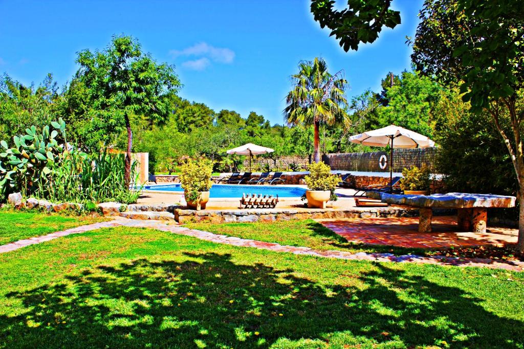 圣胡安包蒂斯塔坎福斯特农场酒店的一个带游泳池、野餐桌和遮阳伞的庭院