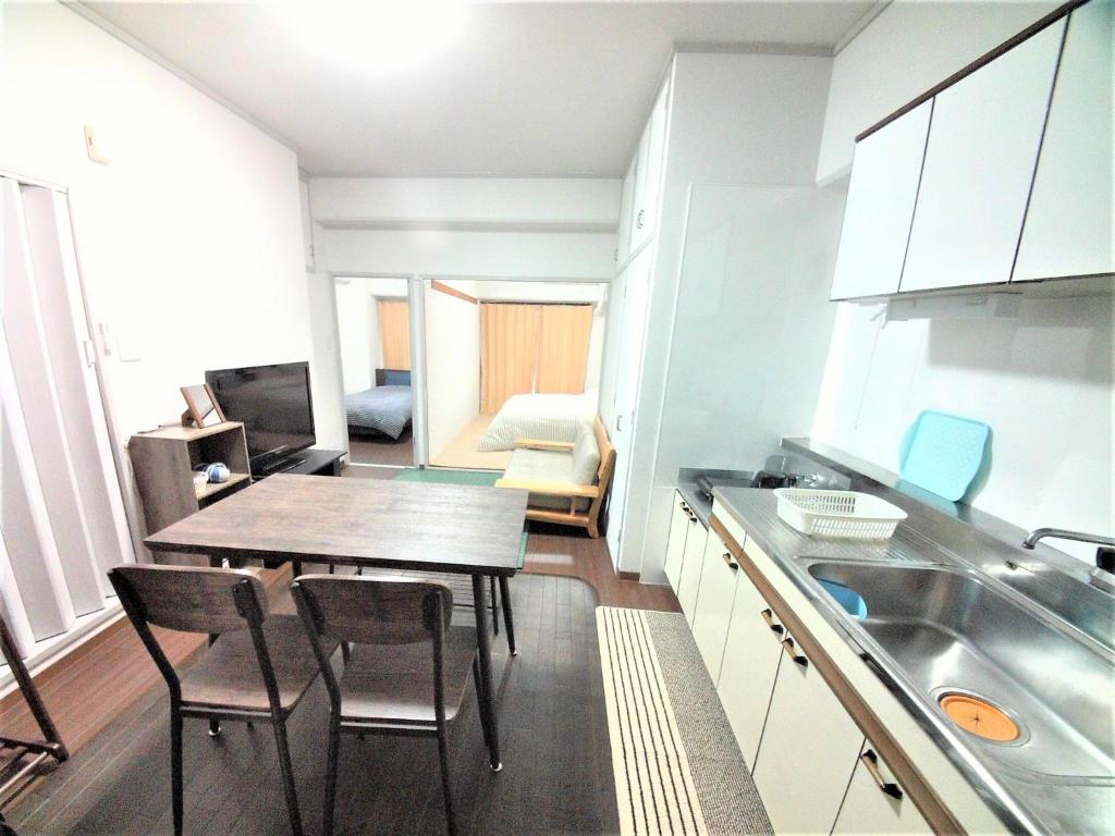 冈山Near Tram Apartment Okayama的厨房以及带桌椅的用餐室。
