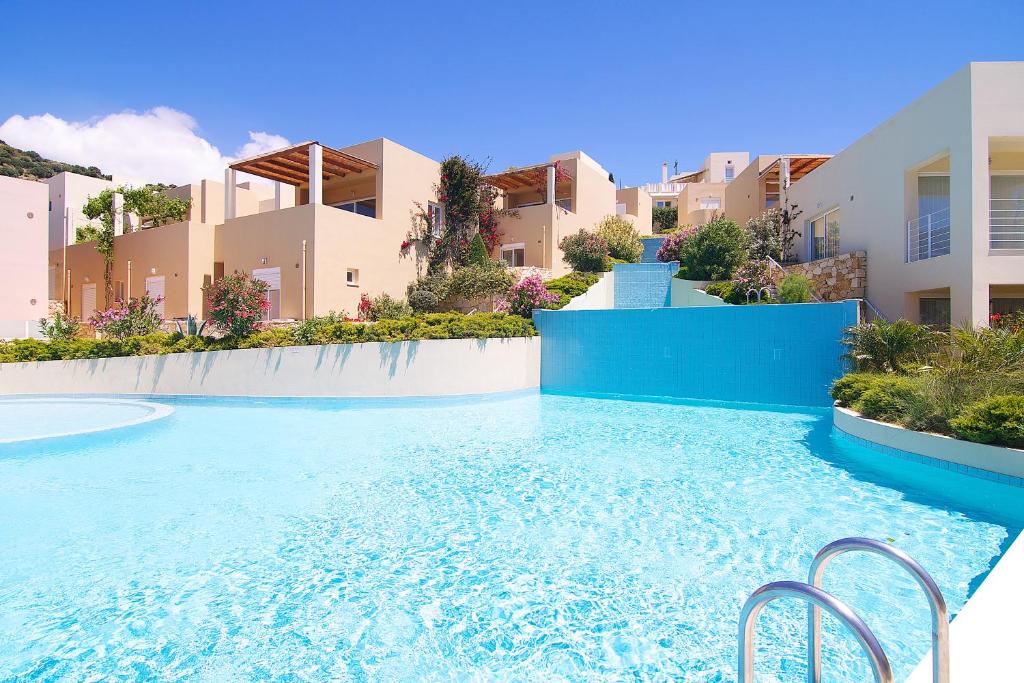 普拉基亚斯Plakias Panorama Homes的一座蓝色海水游泳池,位于部分建筑前