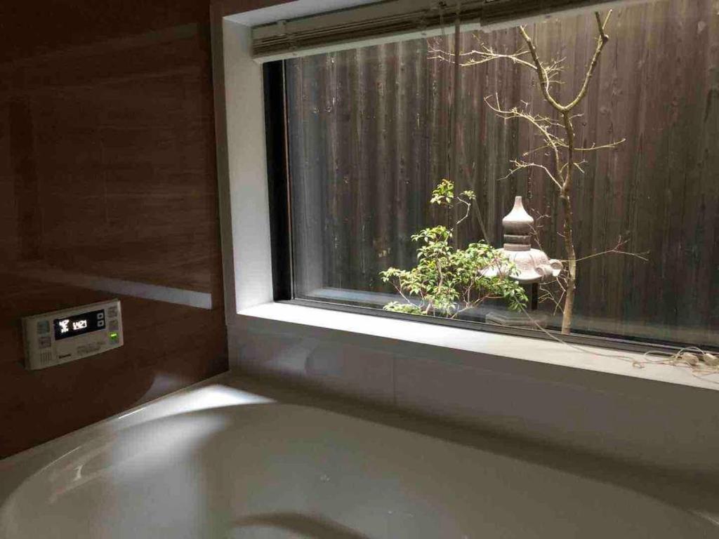 京都FUUTEI Japanese-style lodge的植物窗前的浴缸