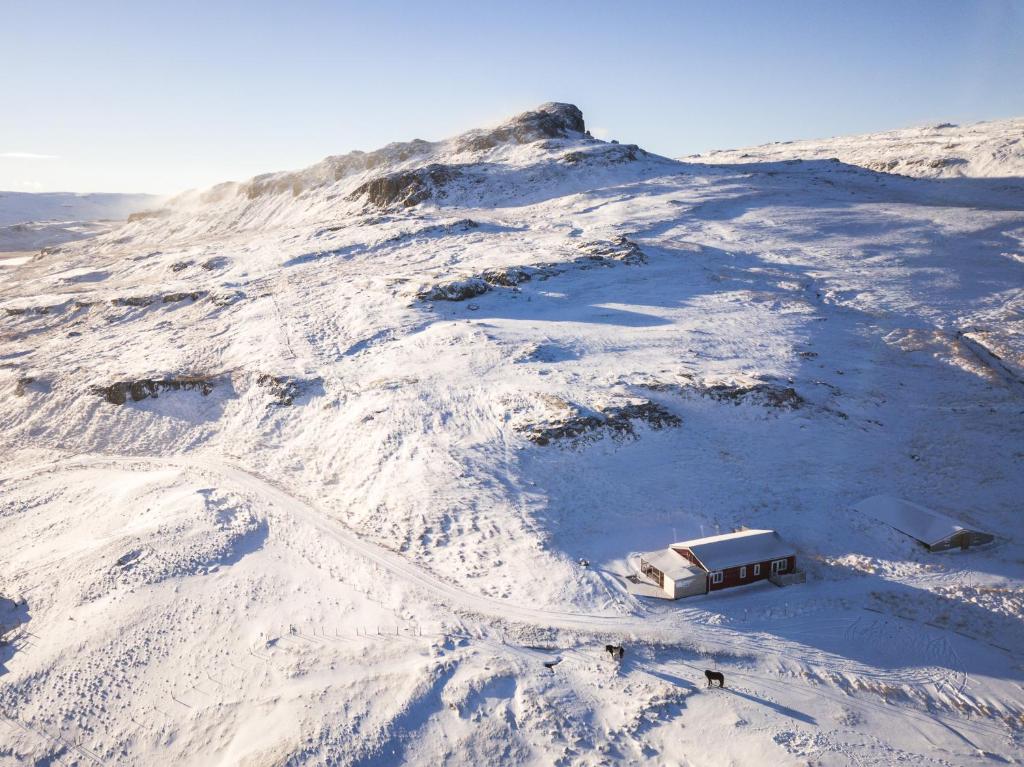 Hrafnabjorg李特拉布雅格旅馆的山里积雪覆盖着,上面有小房子