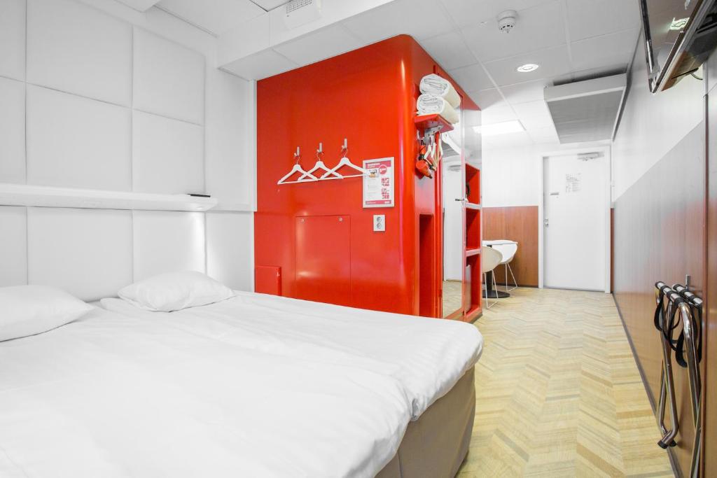 赫尔辛基赫尔辛基隆洛丁街欧美纳酒店的一间设有床铺和红色墙壁的房间