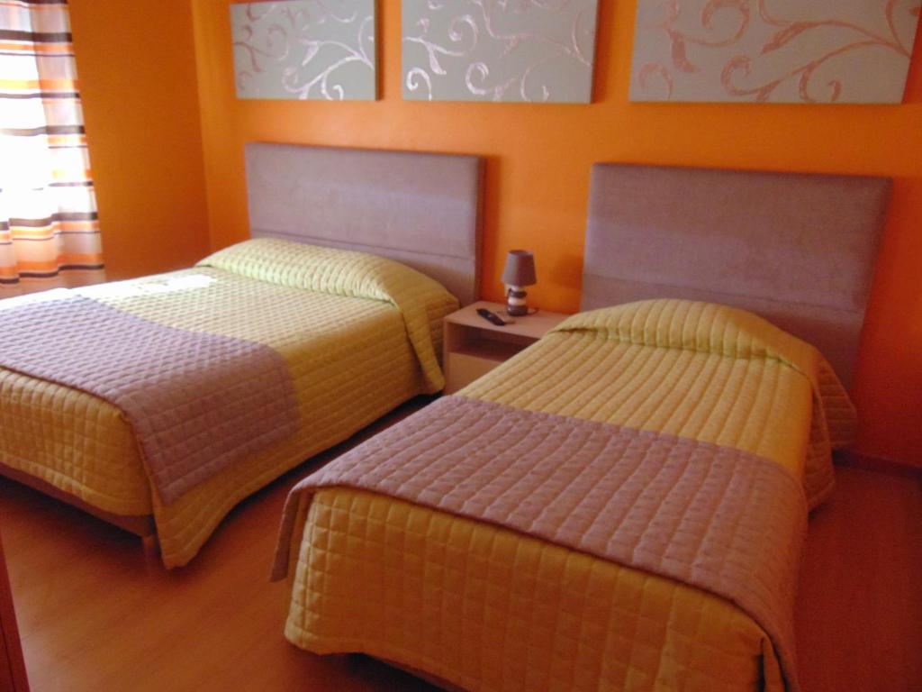 蓬蒂-迪索尔Residencial as Canárias的橙色墙壁客房的两张床