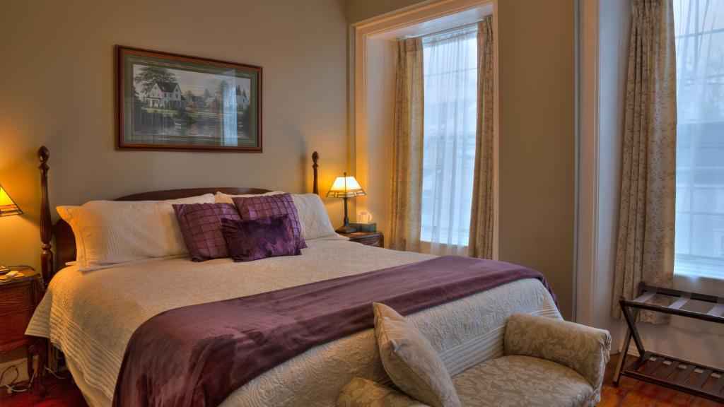 布罗克维尔Sir Isaac Brock B&B Luxury Suites的一间卧室配有一张大床和一把椅子