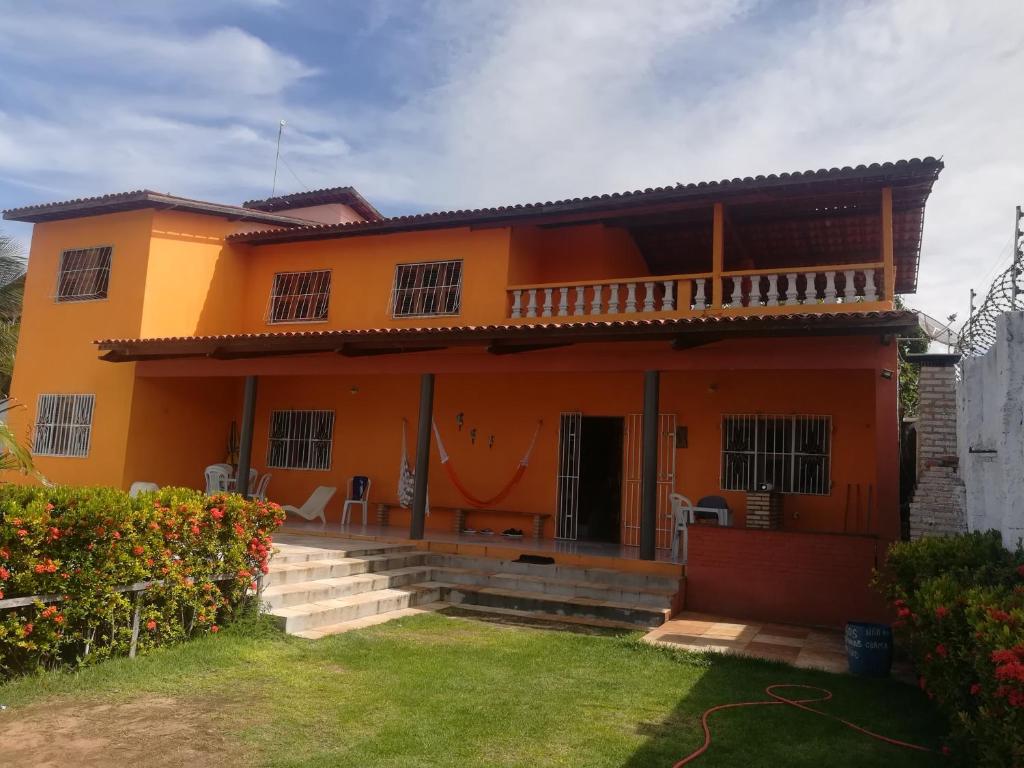 马约尔兰迪亚Casa Majorlandia的一座橙色房子,前面有草坪