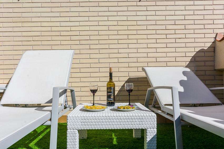 布拉内斯Apartamento Montferrant的一张桌子、两把椅子和一瓶葡萄酒