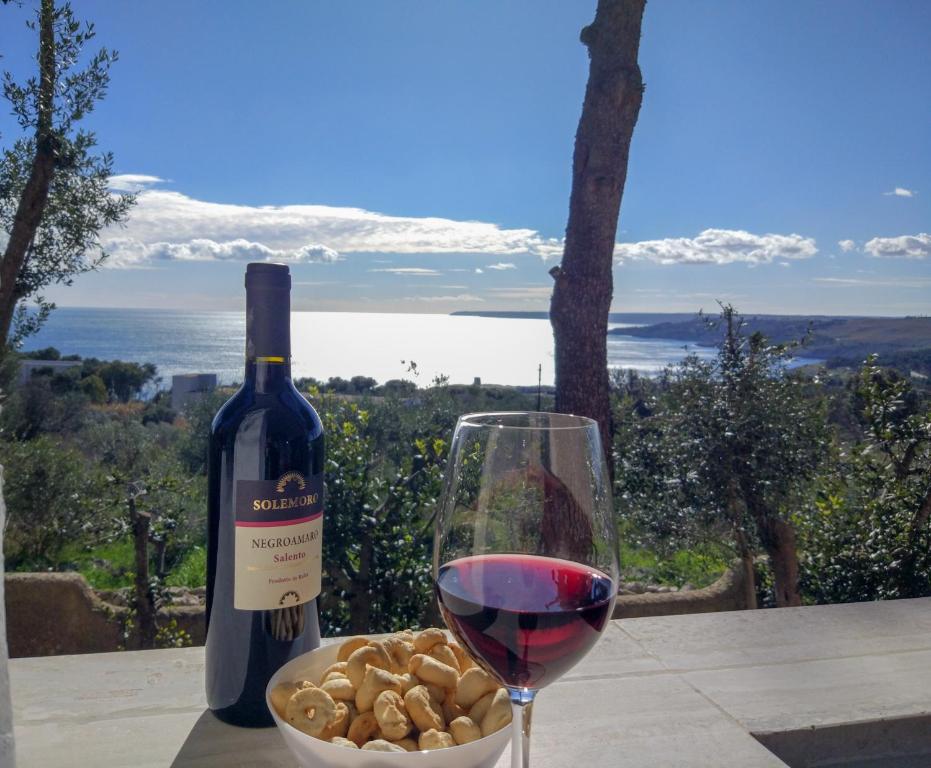 圣凯撒利亚温泉Bilocali Vista Mare的一杯葡萄酒,紧挨着一碗坚果