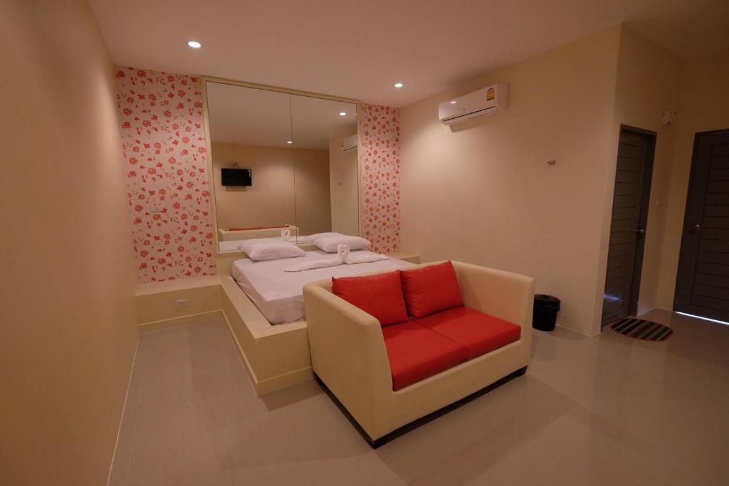 北碧Checkinn Resort Kanchanaburi的一间卧室配有一张床和一张红色椅子