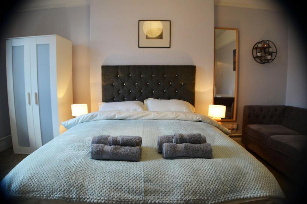 曼彻斯特Gorton Mount Hotel Manchester的一间卧室配有一张大床和两条毛巾