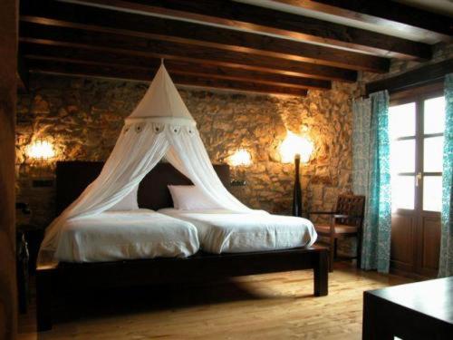 Oronoz-MugaireKuko Hotel - Adults Only的一间卧室配有一张带天蓬的床
