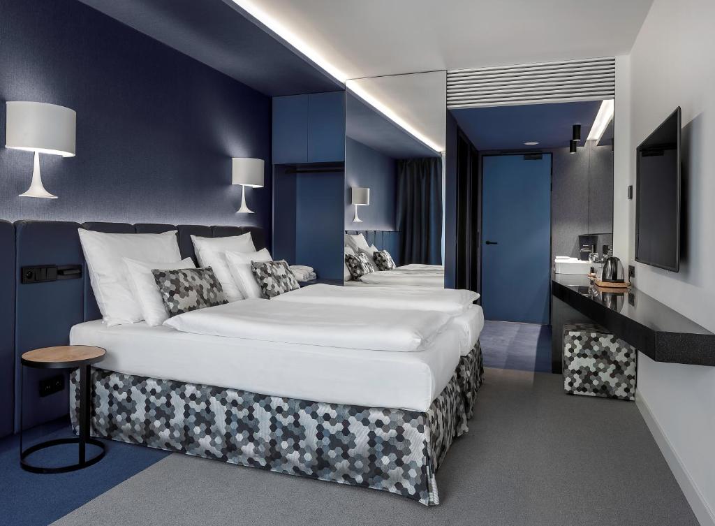 布拉格Urban Creme的酒店客房,设有两张带蓝色墙壁的床