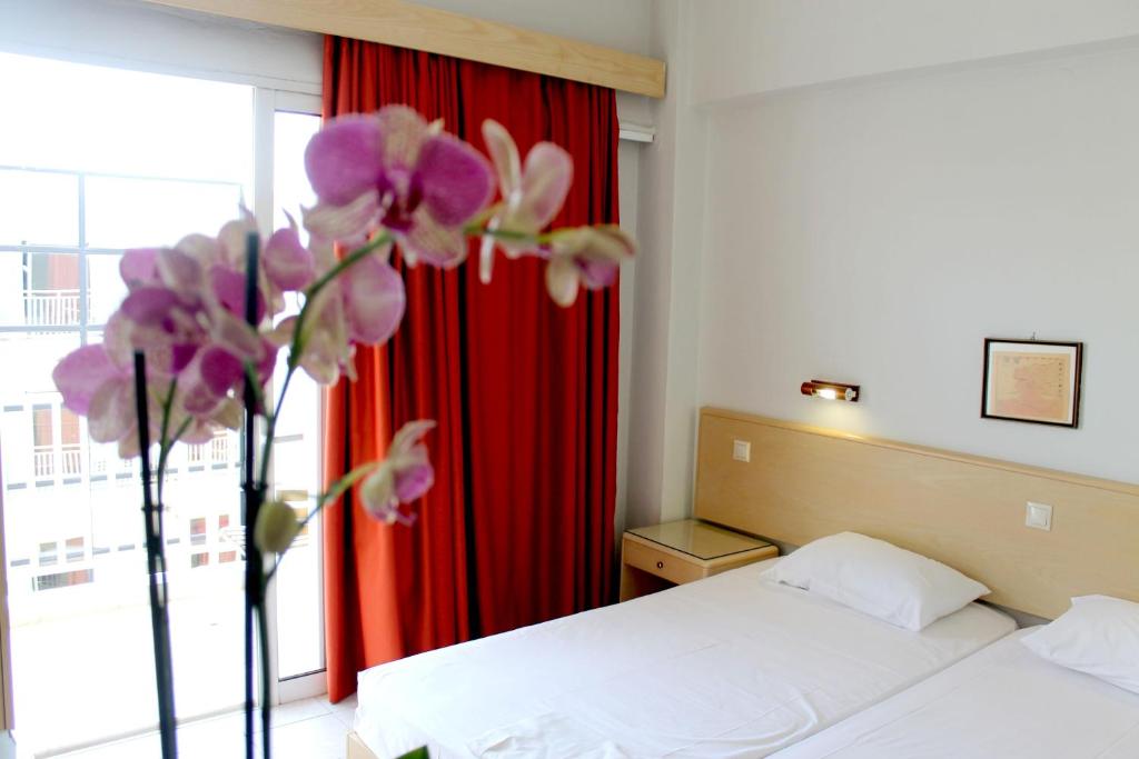 罗德镇萨沃伊酒店的一间卧室设有一张床和一个紫色花窗