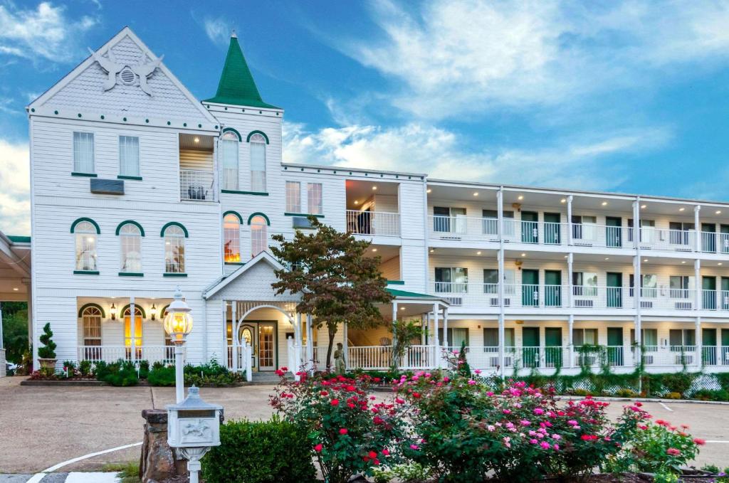 尤里卡斯普林斯Quality Inn Eureka Springs South的一座白色的大建筑,前面有鲜花