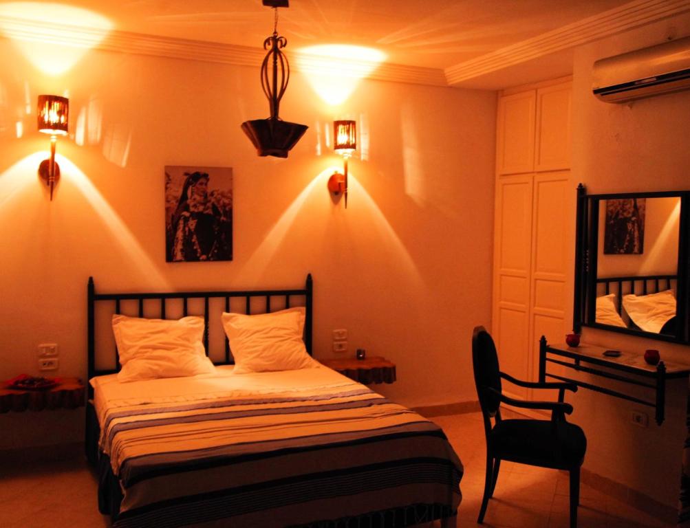 托泽尔Résidence Le Ruisseau的卧室配有床、椅子和灯