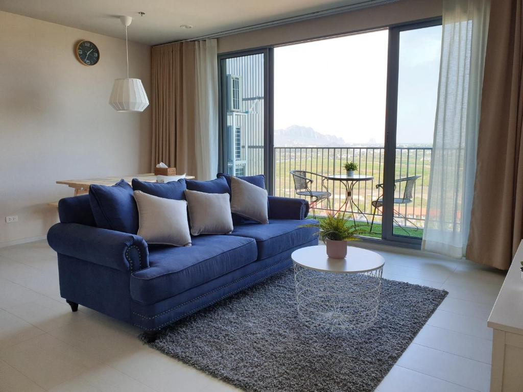 七岩Blu Condo (Chaam - Huahin)的客厅配有蓝色的沙发和桌子