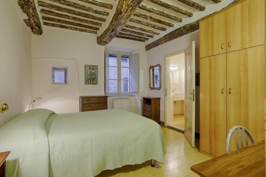锡耶纳Attilio Camere的卧室设有白色的床和木制天花板。