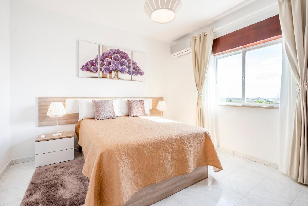 法鲁My Place @ Faro Ria Views的白色的卧室设有床和窗户