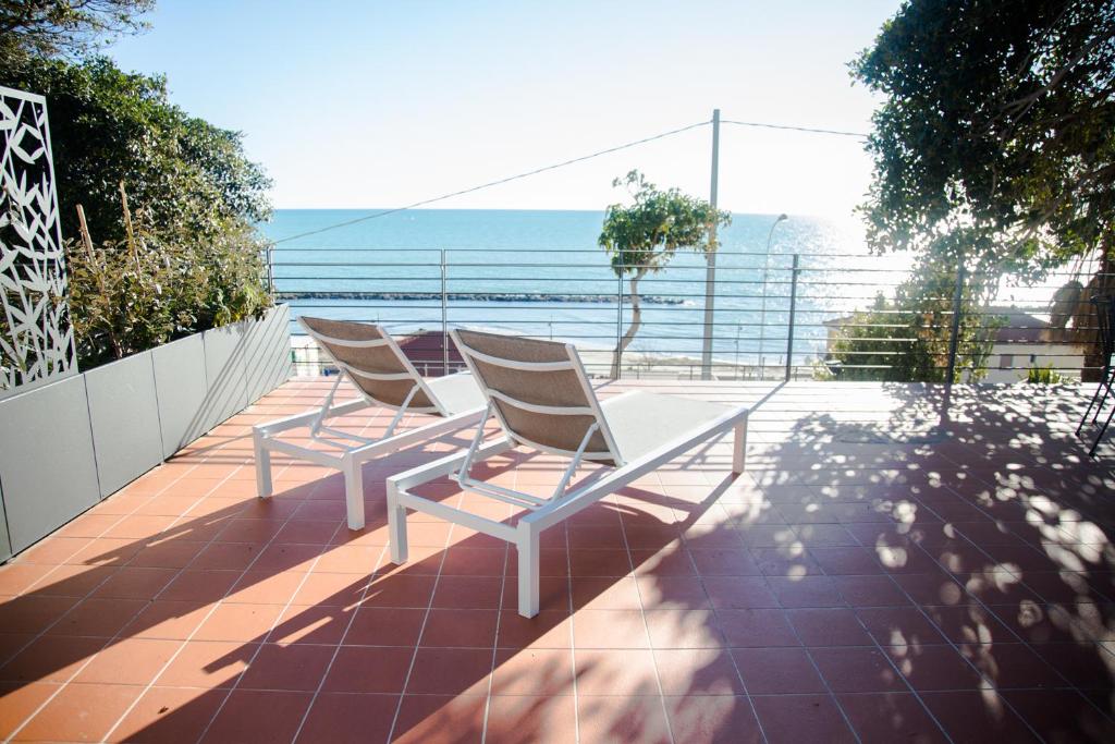 圣托·斯特凡诺·阿尔马尔Terramata Resort Case Vacanza的两把椅子坐在一个俯瞰着大海的阳台