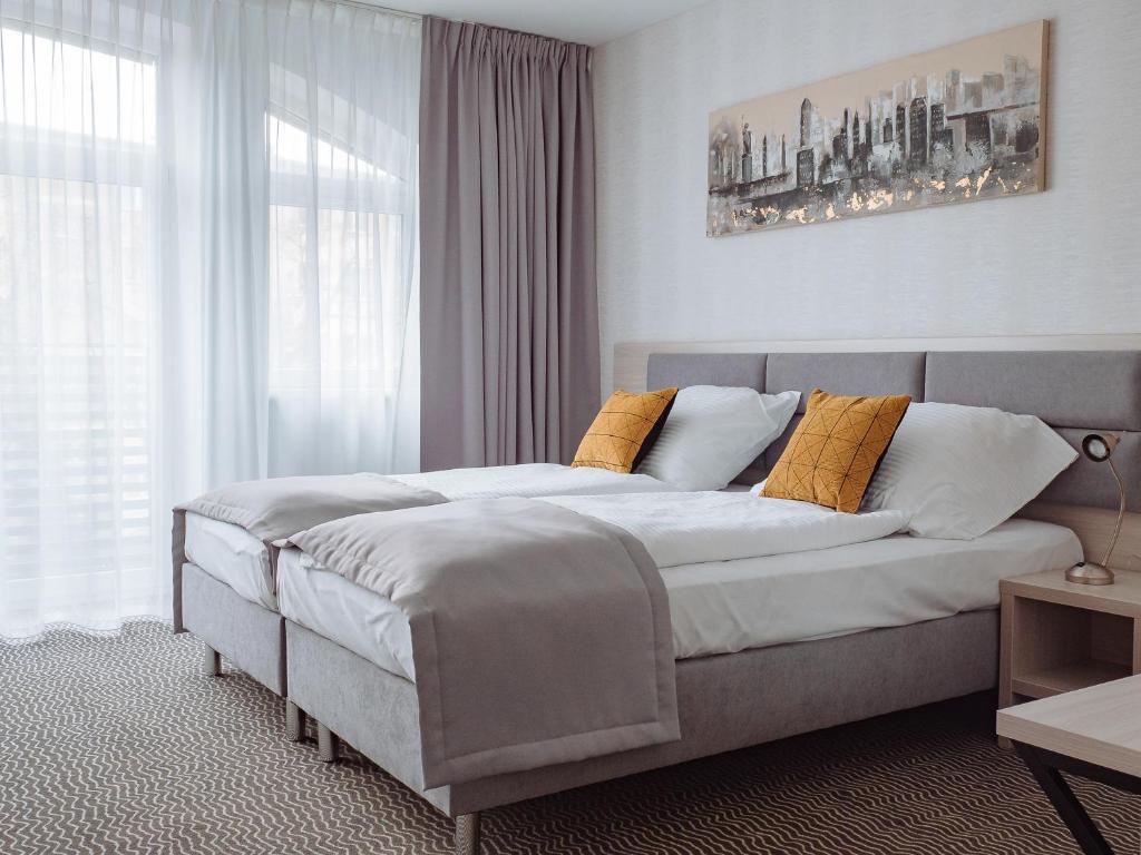 博莱斯瓦维茨Hotel Chrobrego9的一间卧室配有一张带黄色枕头的大床