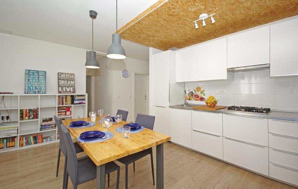 布雷拉Apartment MIVA的厨房配有木桌和白色橱柜。