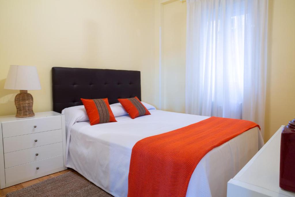马德里Apartamentos Duque Martinez Izquierdo.的一间卧室配有一张带橙色毯子的床