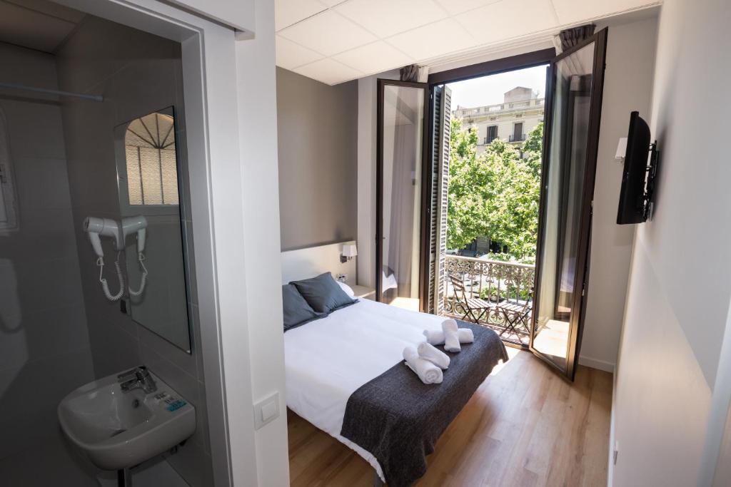 巴塞罗那赫斯特林巴塞罗那格兰维亚酒店的一间卧室配有床、水槽和窗户