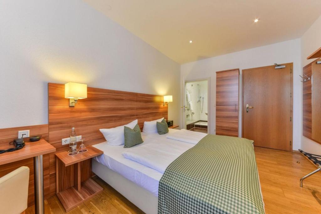 纽伦堡毕胡法旅馆酒店的一间卧室配有一张大床、一张桌子和一张书桌
