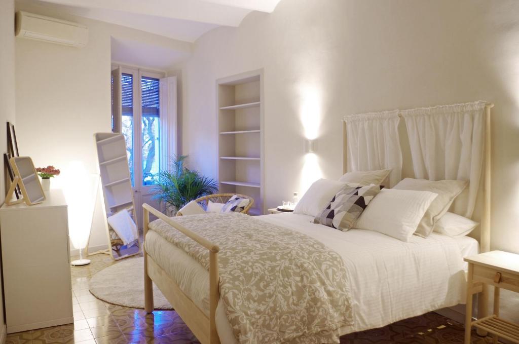 帕拉弗鲁赫尔Apartament en Plaça Nova , Palafrugell的卧室配有白色的床和窗户。