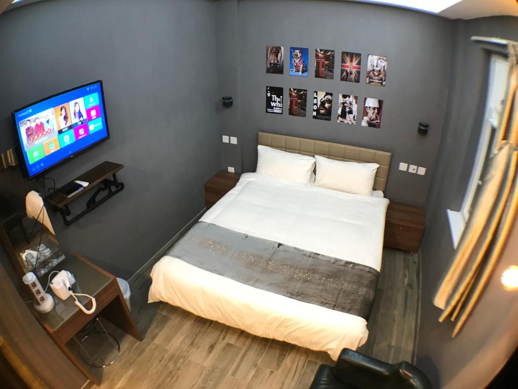 香港精品旅馆的一间小卧室,配有一张床和电视