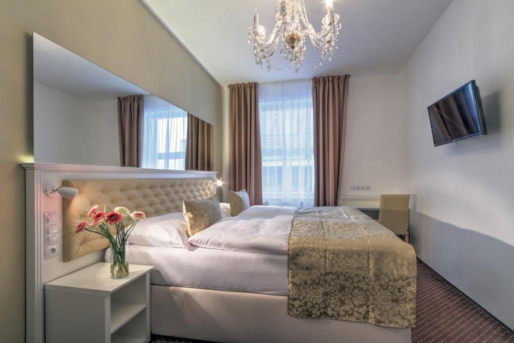 布拉格金牛座酒店的酒店客房,配有一张床和吊灯