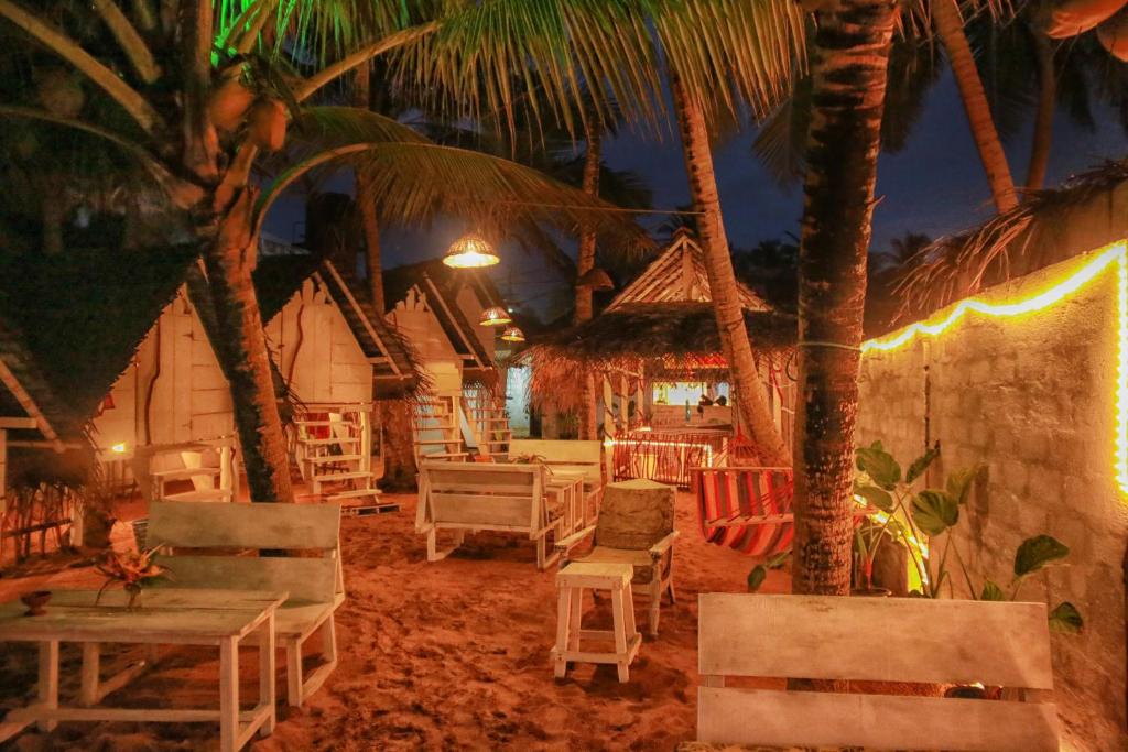 高尔Oynise Beach Cabin的海滩上,晚上有椅子和棕榈树