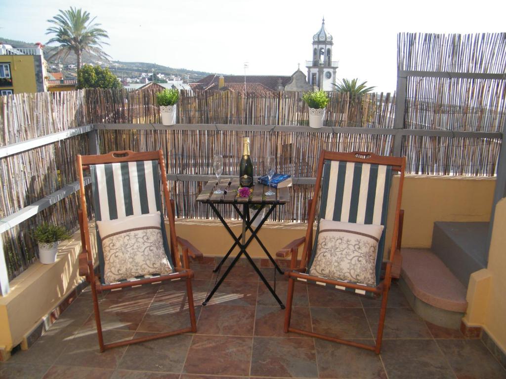 格拉纳迪利亚德亚沃纳Casa Rural San Francisco的天井配有两把椅子和一张桌子及一瓶葡萄酒