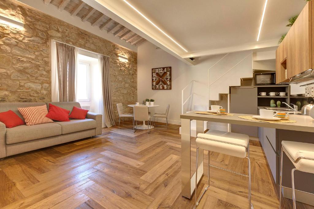 佛罗伦萨Mamo Florence - Mattonaia Apartment的厨房以及带沙发和桌子的客厅。