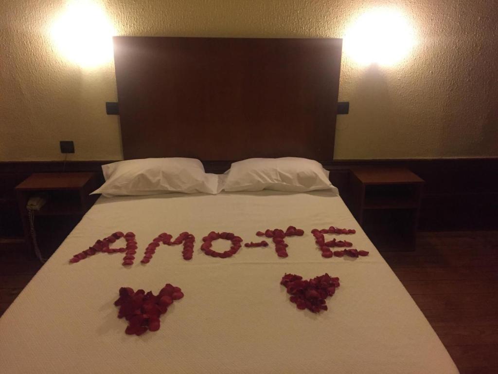波尔图爱克扎果酒店的上面有玫瑰的床铺,上面有水星的字样