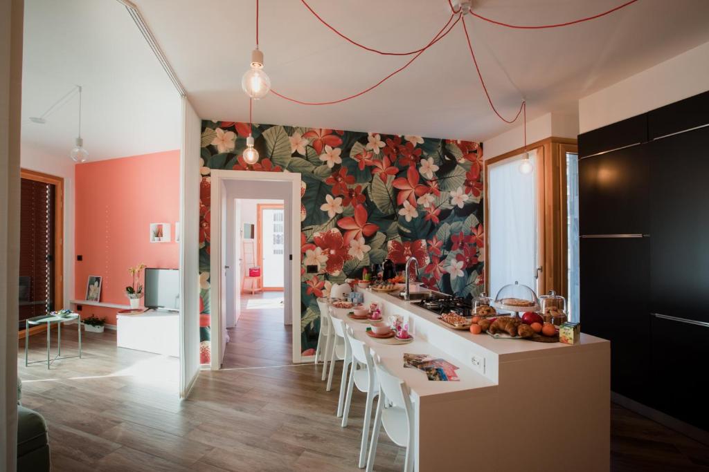 奇列B&B LeTerrazze Boutique Hotel - Torino的厨房配有长桌子、椅子和花卉墙