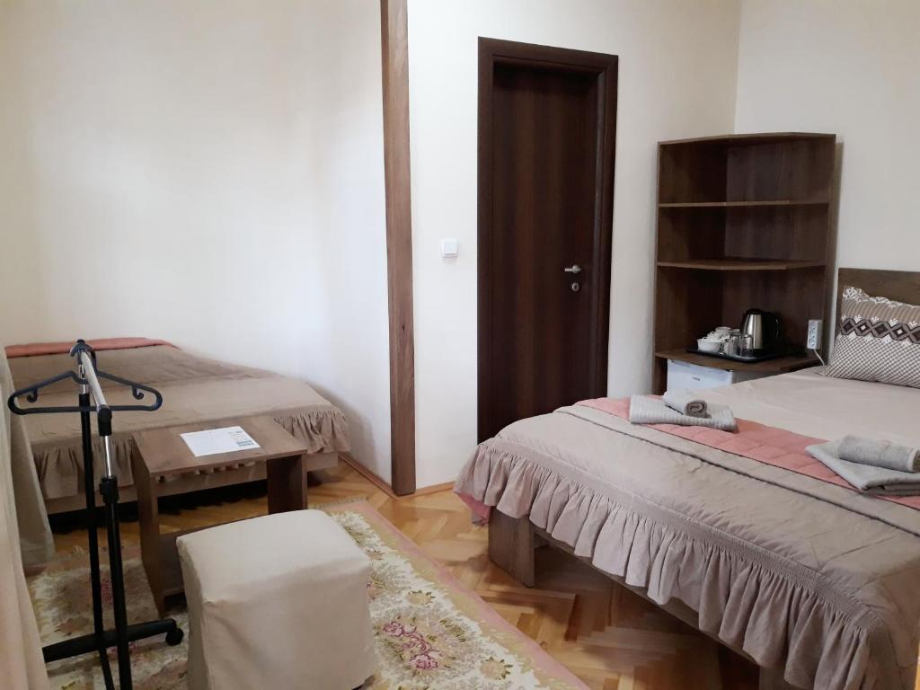 盖夫盖利亚Villa Domina的一间设有两张床、一张桌子和一把椅子的房间