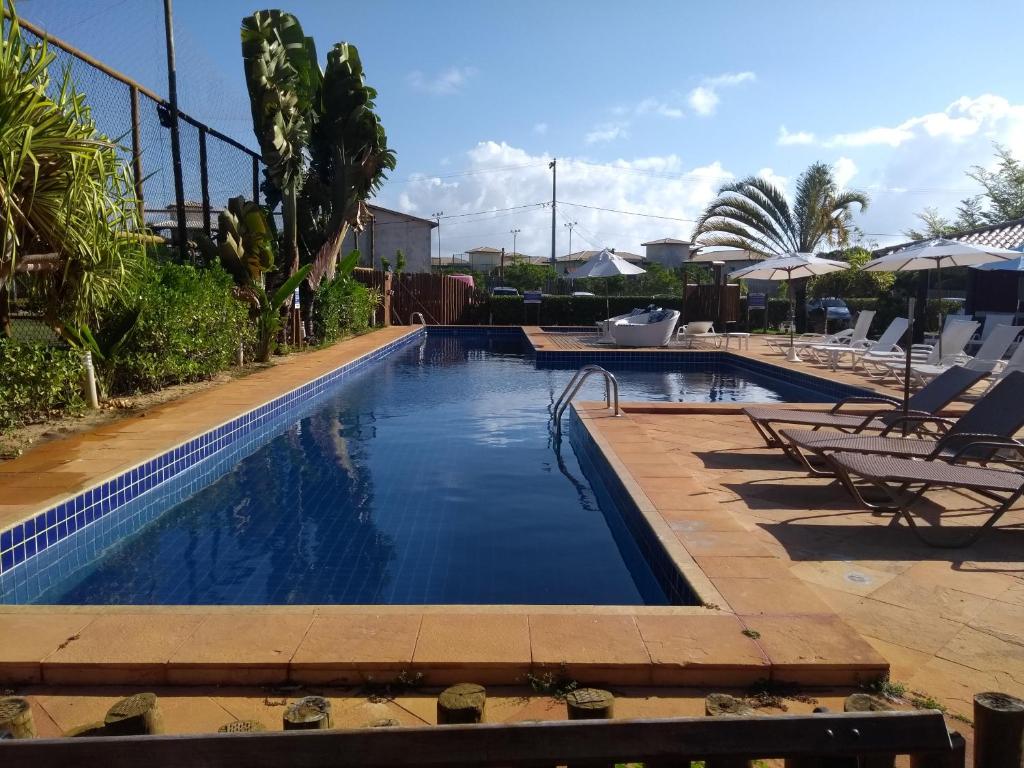 伊塔齐米林Itacimirim - Quinta das Lagoas Residence的一个带椅子和遮阳伞的游泳池