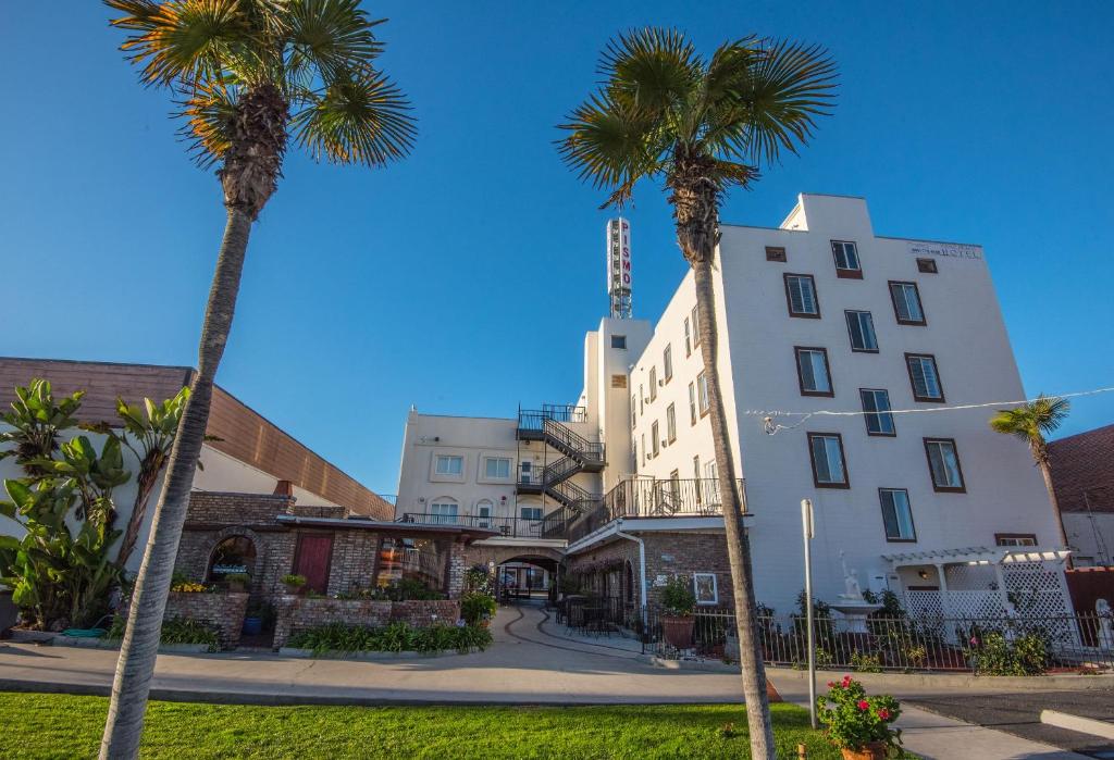 皮斯莫比奇庇斯摩海滩酒店的一群棕榈树在一座建筑前