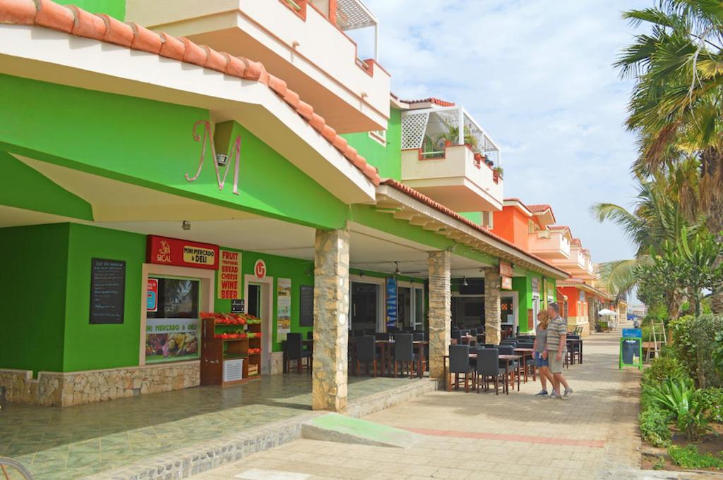 圣玛丽亚Djasal Moradias的一间拥有绿色和橙色建筑的餐厅