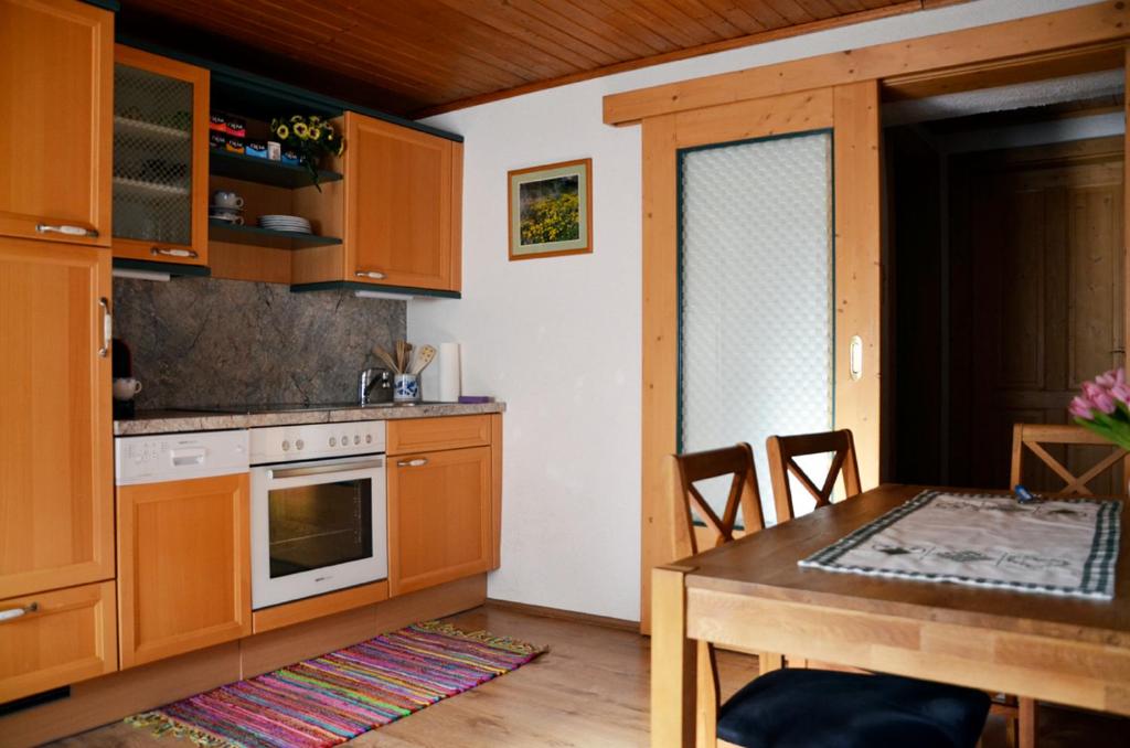 格明德Ferienwohnung Blockheide的厨房配有木制橱柜、餐桌和用餐室