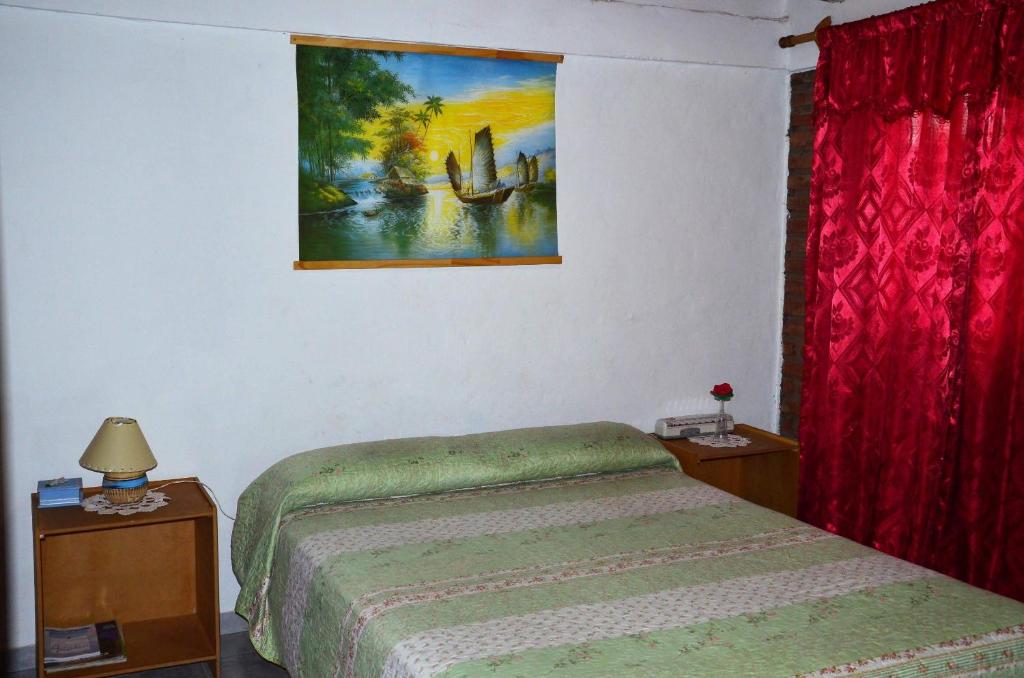 马拉圭El Pasaje的卧室配有一张床,墙上挂有绘画作品