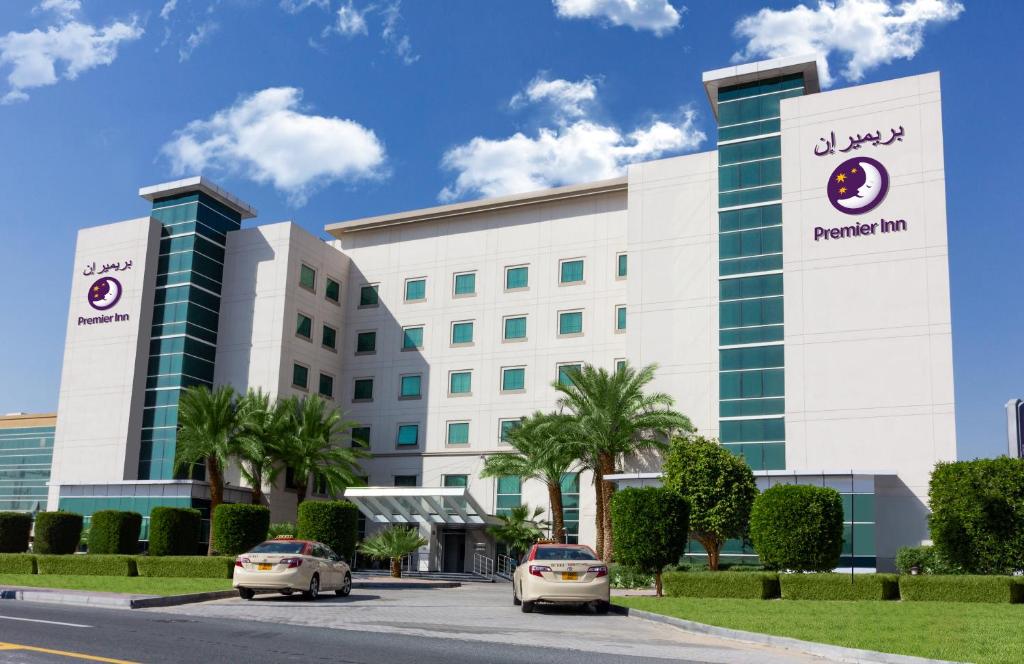 迪拜迪拜投资公园普瑞米尔酒店的停在酒店门前的两辆汽车