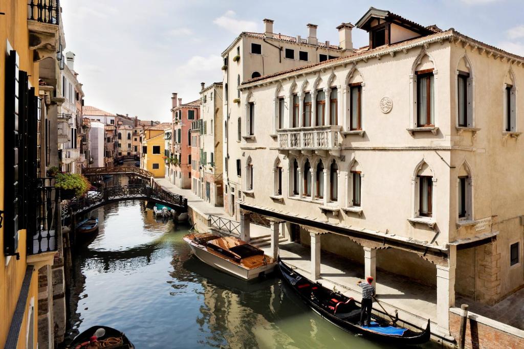 威尼斯Maison Venezia | UNA Esperienze的享有两栋建筑之间的运河景色,设有吊船
