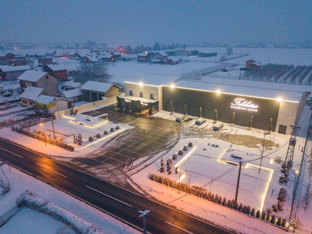 拉克塔希Motel Felikitas的一座大建筑,地面上积雪,灯光照亮