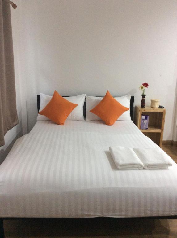 曼谷Happy Hostel的一张带橙色和白色枕头的床