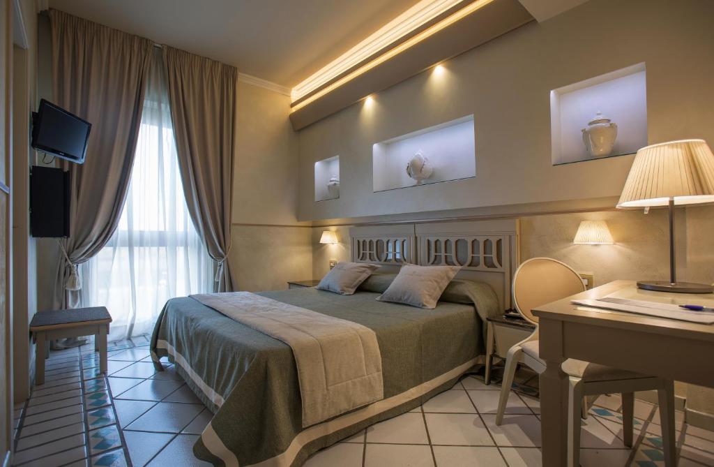 加拉蒂纳希尔米塔吉酒店的配有一张床和一张书桌的酒店客房
