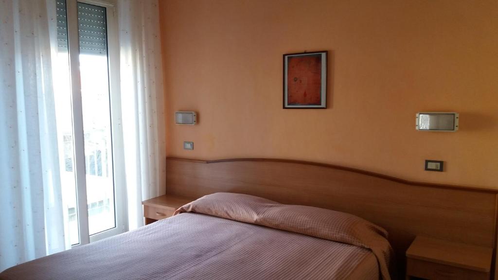 西尼加利亚Albergo Moretti的一间卧室设有一张床和一个大窗户