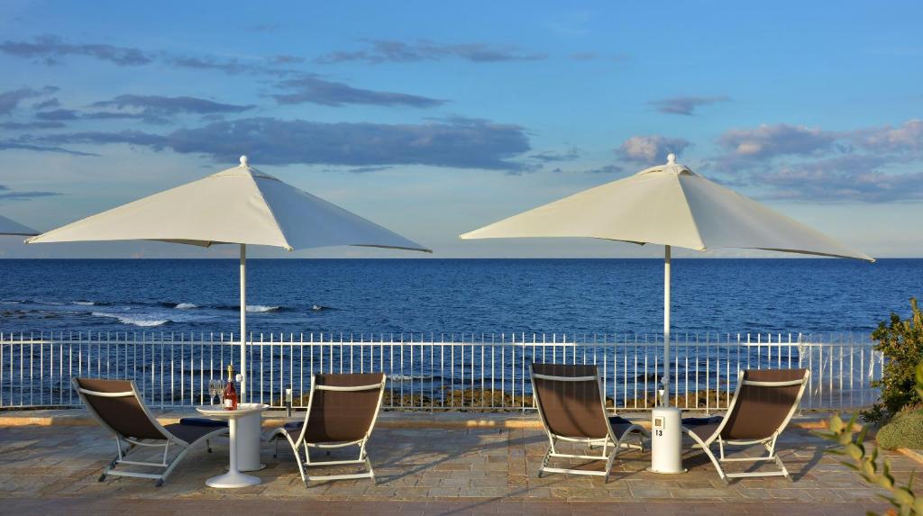 滨海波利尼亚诺Vilu Suite Mare的海滩上一组桌椅和遮阳伞