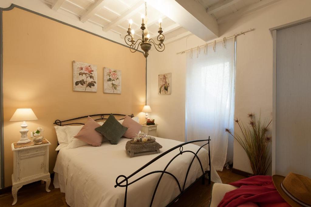 佛罗伦萨Belvedere Suite Florence的一间卧室配有一张带白色床单和吊灯的床。